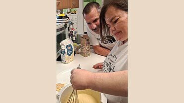 Ein Mann und eine Frau bereiten Teig in der Küche zu.
