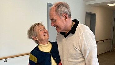 Ein älteres paar lächelt sich an.