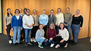 13 compass-Kolleg*innen der Weiterbildung stehen als Gruppe beisammen.