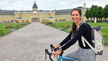 Pflegeberaterin Melanie Moreau mit dem Rad vor dem Karlsruher Schloss.