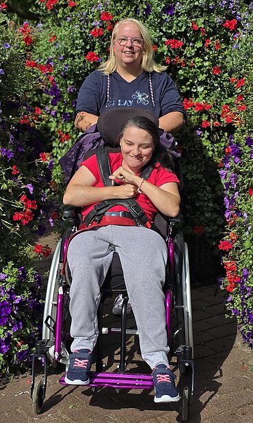 Das Bild zeigt Jennifer Reich und ihre Tochter vor einem blühenden Busch.