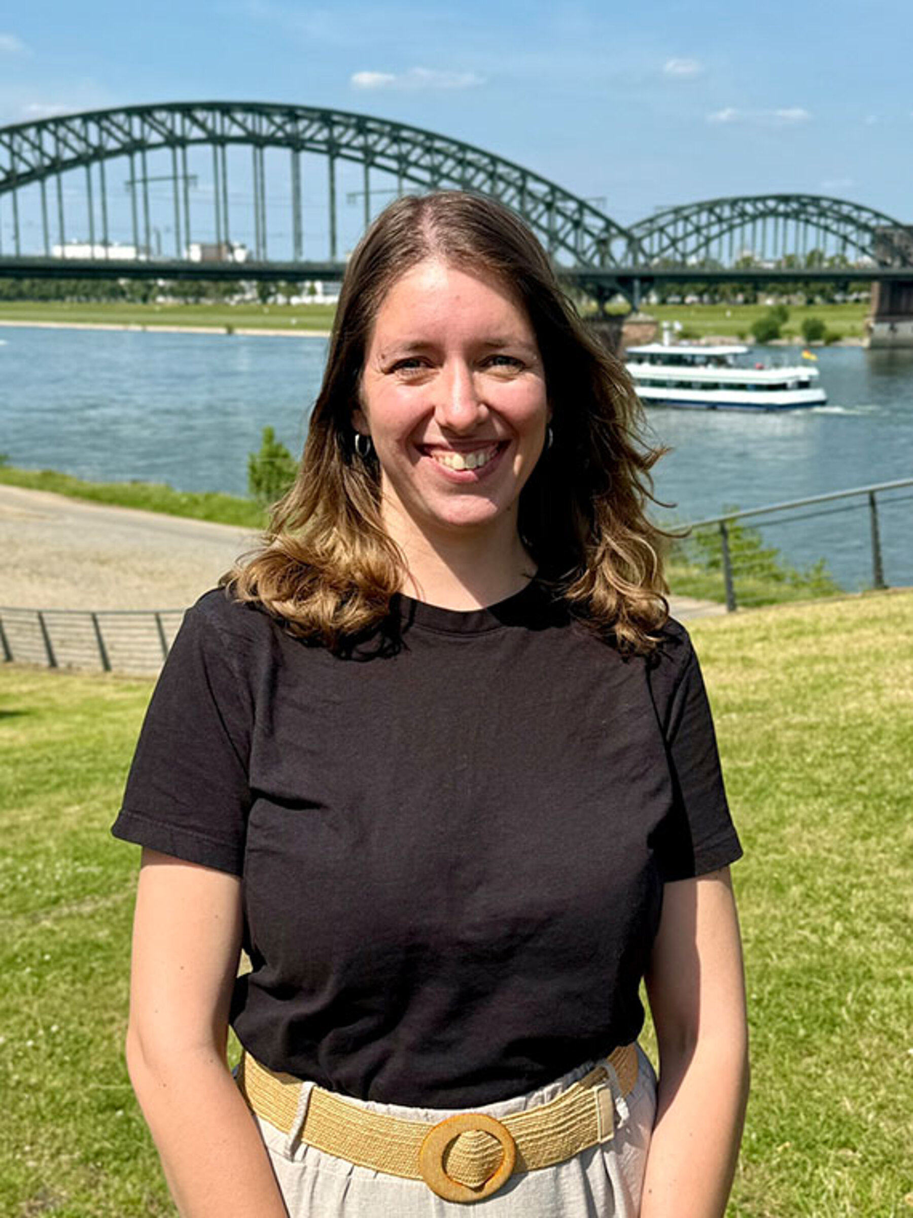 Pflegeberaterin Leonie Hausmann am Rhein in Köln. Im Hintergrund die Südbrücke.