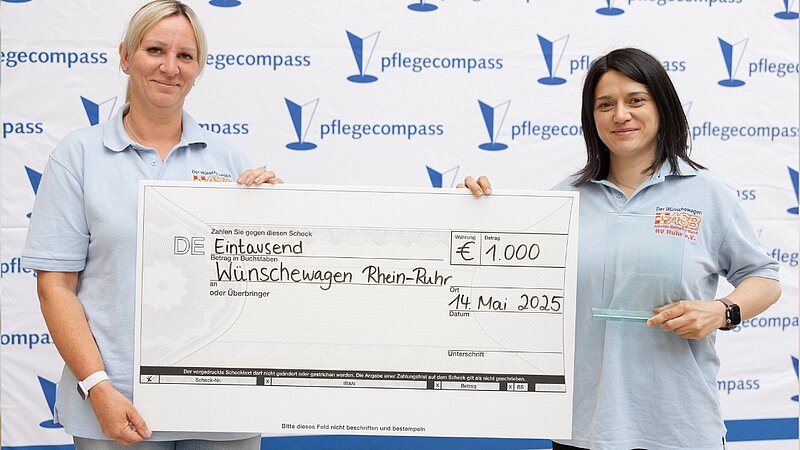 Aufnahme zweier Vertreterinnen des Gewinner-Angebots "Wünschewagen Rhein-Ruhr" mit einem großen Scheck.