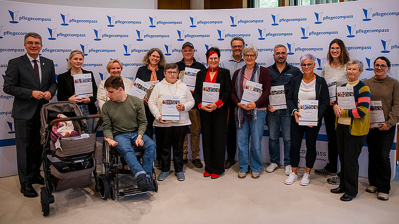 Eine große Personengruppe, bestehend aus den nominierten pflegenden Angehörigen und ehrenamtlich Pflegenden, steht mit dem Landrat in einer Reihe.