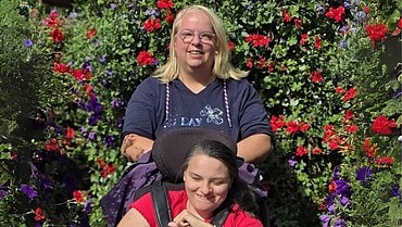 Das Bild zeigt Jennifer Reich und ihre Tochter vor einem blühenden Busch.