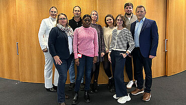 Neun compass-Kolleg*innen, die kürzlich die Weiterbildung erfolgreich abgeschlossen haben.