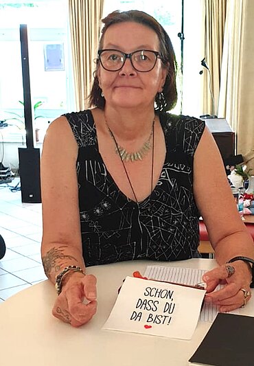 Gabriele Bußmann sitzt vor Fenstern.
