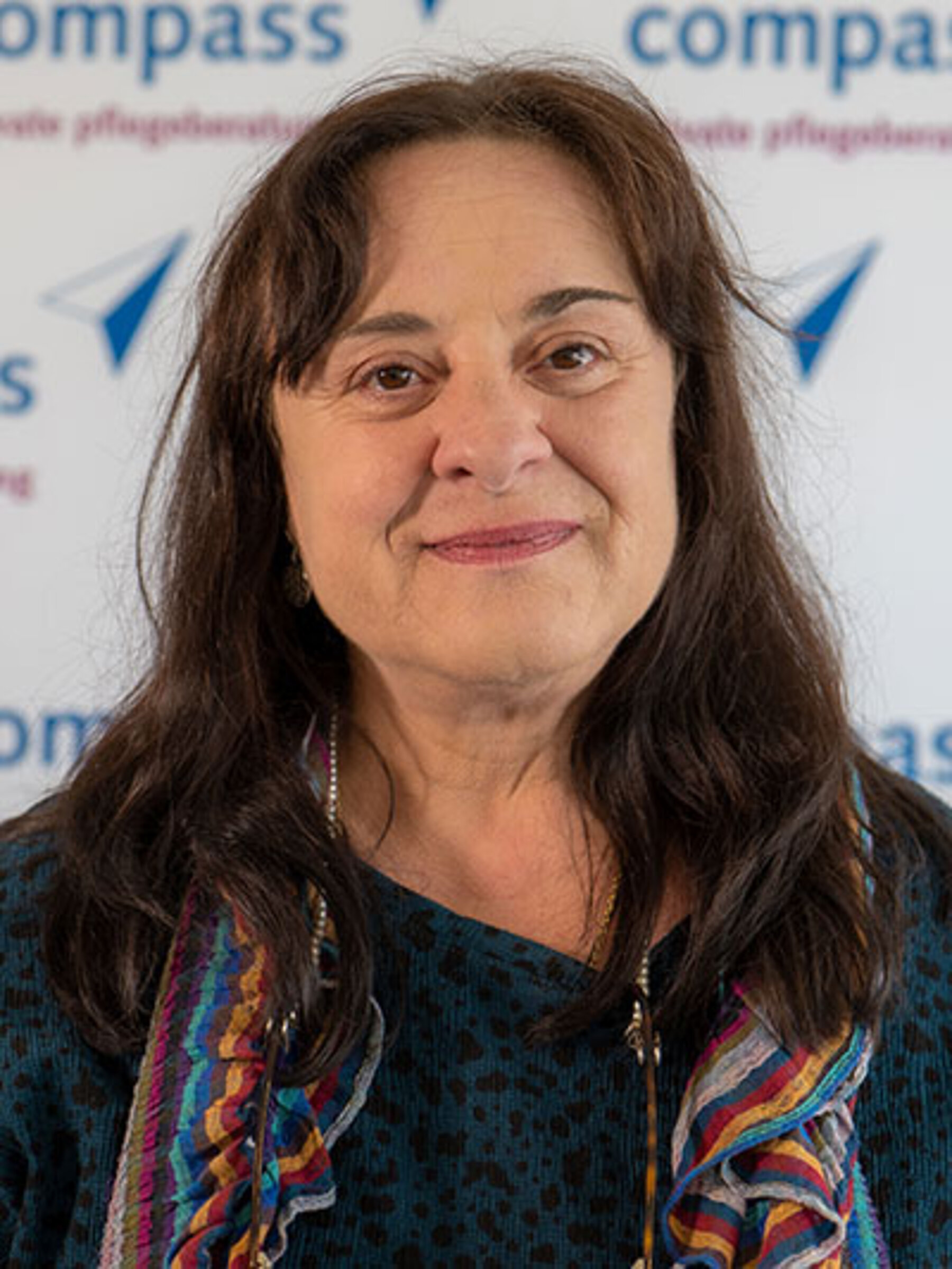 Eine Frau mit mittellangen braunen Haaren lächelt in die Kamera. compass-Pflegeberaterin Marion Bardi.