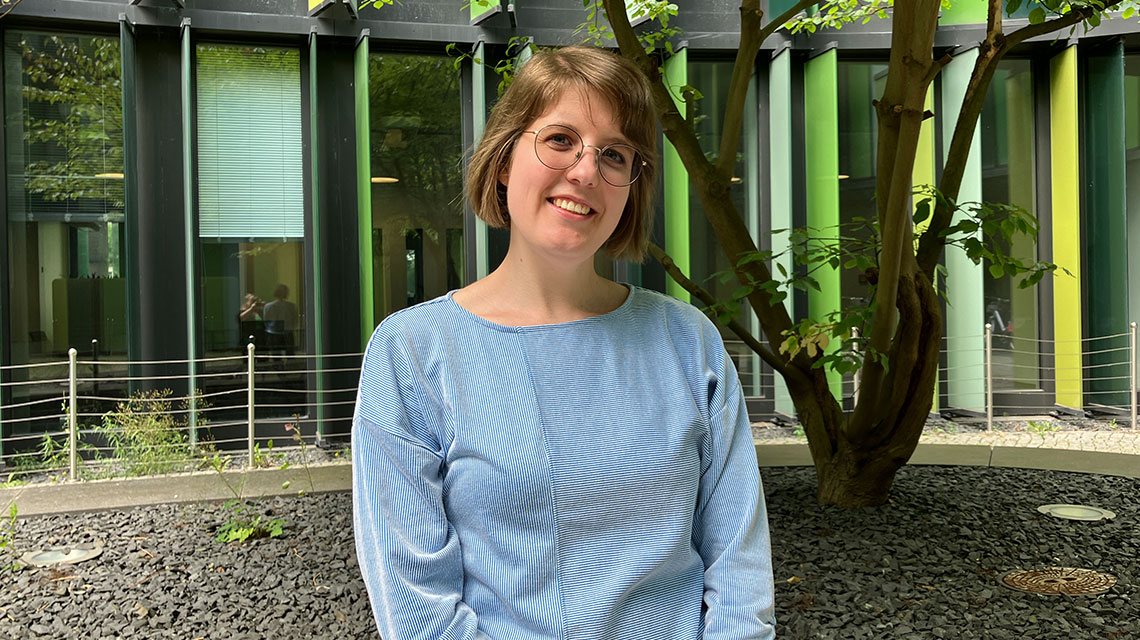 Bild von Irina Hans lachend vor Baum.
