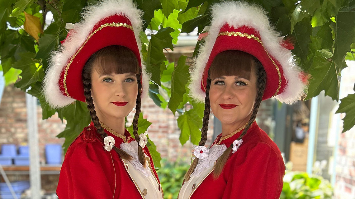 Zwei compass-Mitarbeiterinnen tragen ihre traditionelle Karnevalsvereinskleidung. 