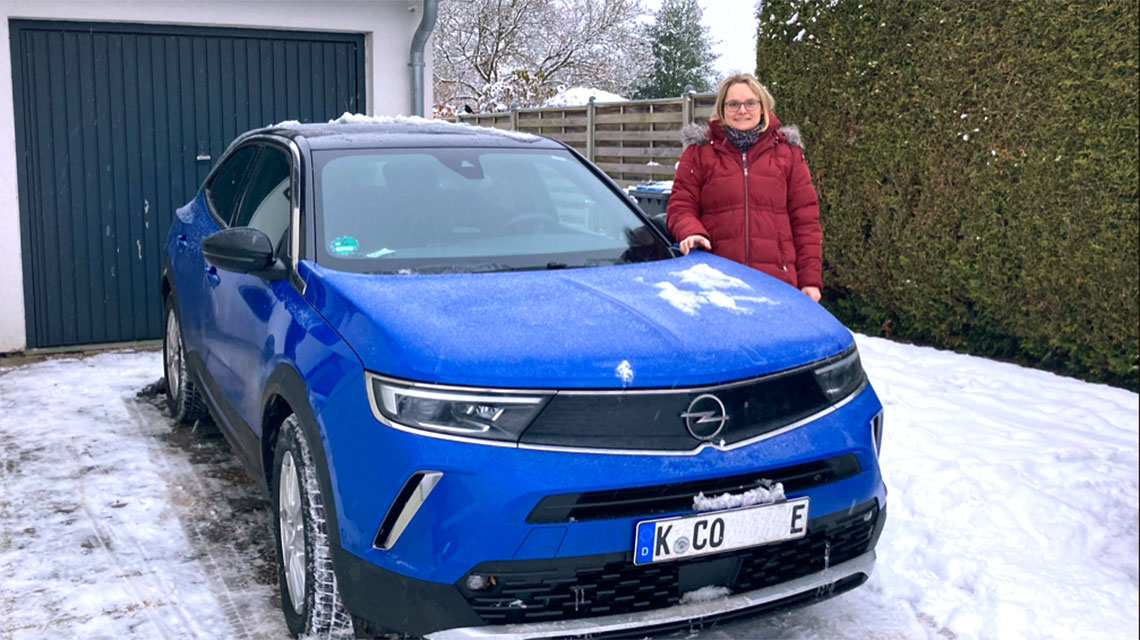 Pflegeberaterin und ihr E-Auto im Schnee
