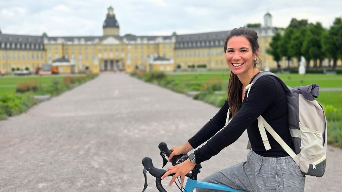 Auf dem Bild sieht man Pflegeberaterin Vanessa Pfeifer auf dem Rad vor dem Schloss.